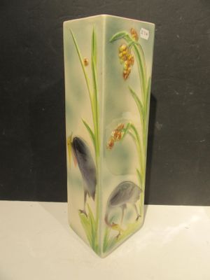 a vase with a bird on it sitting on a table