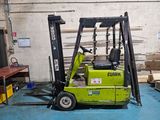 a forklift in a warehouse with pallets in the background