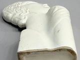 a statue of a hand holding a book on a table