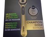 the packaging of a razor with a gold handle is shown