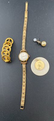 une montre en or et un bracelet en or posés sur une table