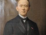 portrait d'un homme en costume-cravate devant un fond marron