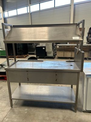 une photo d'une table de travail en acier inoxydable dans un entrepôt