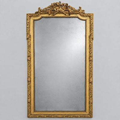 un miroir à cadre doré accroché au mur d'une pièce