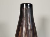 a black and brown vase sitting on top of a table