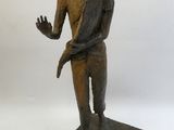 statue en bronze représentant un homme tenant un oiseau sur l'épaule
