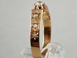 a gold ring with pearls on it sitting on a clear surface