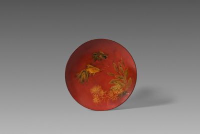 une image représentant une assiette rouge et dorée ornée de fleurs