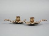 pair of antique brass candlesticks on a stand on a gray background