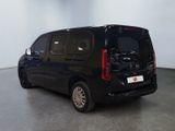 a picture of a black van parked in a large room