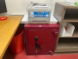 a printer sitting on top of a red cabinet