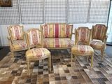 quatre chaises et un canapé posés sur un tapis dans une pièce