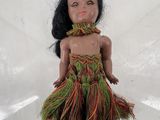 une image représentant une poupée représentant une femme vêtue d'une jupe en paille