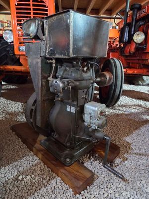 un petit moteur posé sur un socle en bois dans une grange