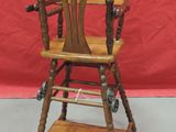 a small wooden high chair with wheels on the floor