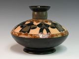a black and white vase sitting on a white table