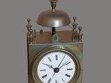une horloge en argent surmontée d'une cloche