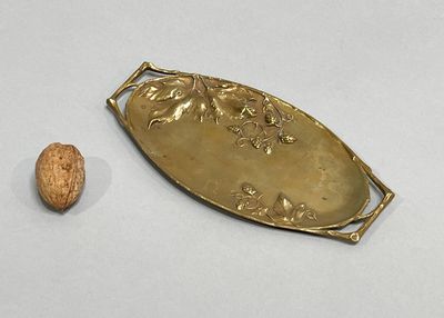 a gold plate with a walnut on it next to it