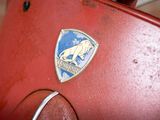 a close up of a red scooter with a badge on it
