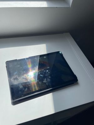 a tablet computer sitting on a table in front of a window