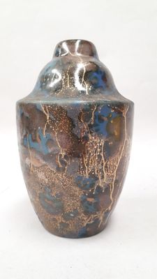 a blue and brown vase sitting on a white surface