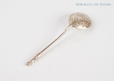 a silver spoon with a handle on a white surface