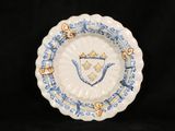 a blue and white plate with a crest on it