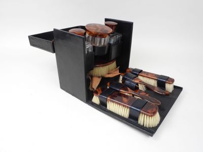 a black box with brushes and a bottle of liquid in it