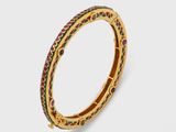 a close up of a gold bangle with multi colored stones