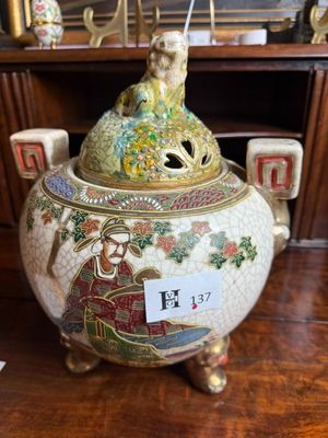 a vase that has a bird on top of it