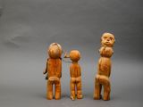 two wooden figurines of a man and a woman and a child