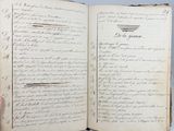 a hand holding an open book with writing on it