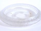 un saladier en verre transparent muni d'un couvercle, posé sur une surface blanche