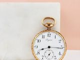 an antique pocket watch sitting on a marble block next to a marble block