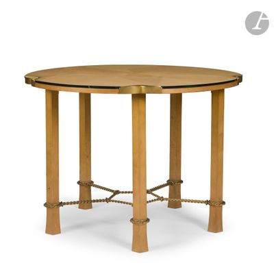 une table ronde en bois avec des pieds cordés et un plateau en verre