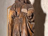 a statue of a man holding a book in a room