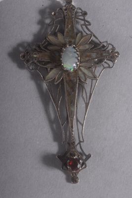 une croix en argent avec une pierre au centre