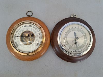 two clocks that are on the wall next to each other