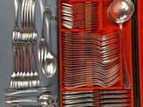 silverware in a red case on a gray surface with spoons, forks, spoons, and spoons