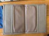 leather wallet on a table next to a pair of sunglasses and a pair of scissors