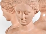 three statues of a man and a woman on a white background