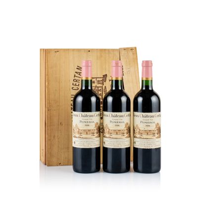 three bottles of red wine in front of a wooden box