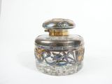 a glass jar with a silver lid sitting on a white surface