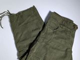 an image of a pair of olive green pants on a white surface