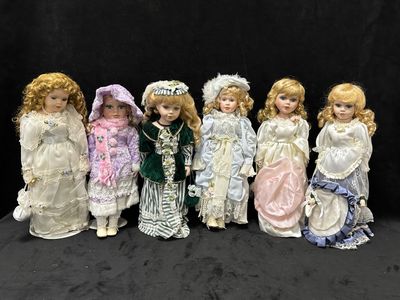 sept poupées en porcelaine sont alignées sur un fond noir