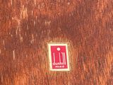 a red sticker on a piece of wood with a knife and fork