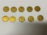 a bunch of gold coins sitting on top of a white surface
