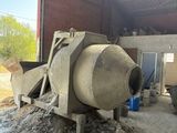une bétonnière dans un bâtiment où se trouve un tas de gravats