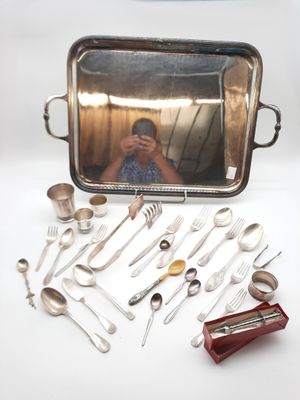 un plateau en argent avec des cuillères, encore des cuillères et un miroir