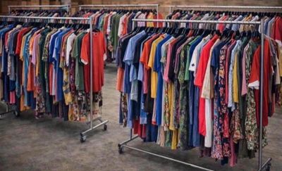beaucoup de vêtements suspendus à une étagère dans une pièce